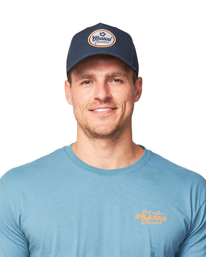 Front view of a male model wearing the Navy Okanui Billboard adult snapback trucker cap