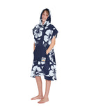 A kid with its hood on and hands in the pocket wearing the Okanui Hooded Towel in Hibiscus Navy color