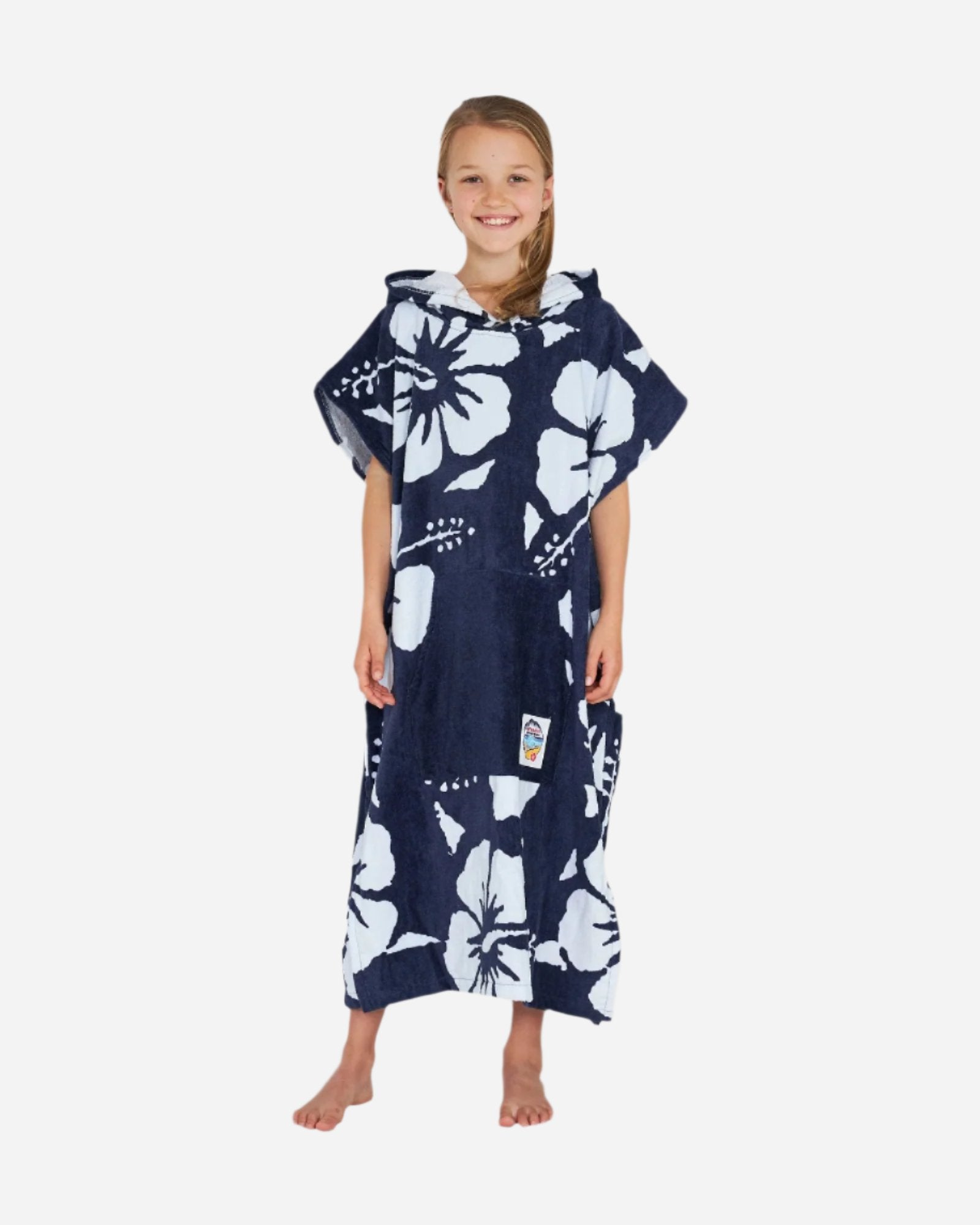 Front view of a girl with hood off wearing the Okanui Hooded Towel in Hibiscus Navy color