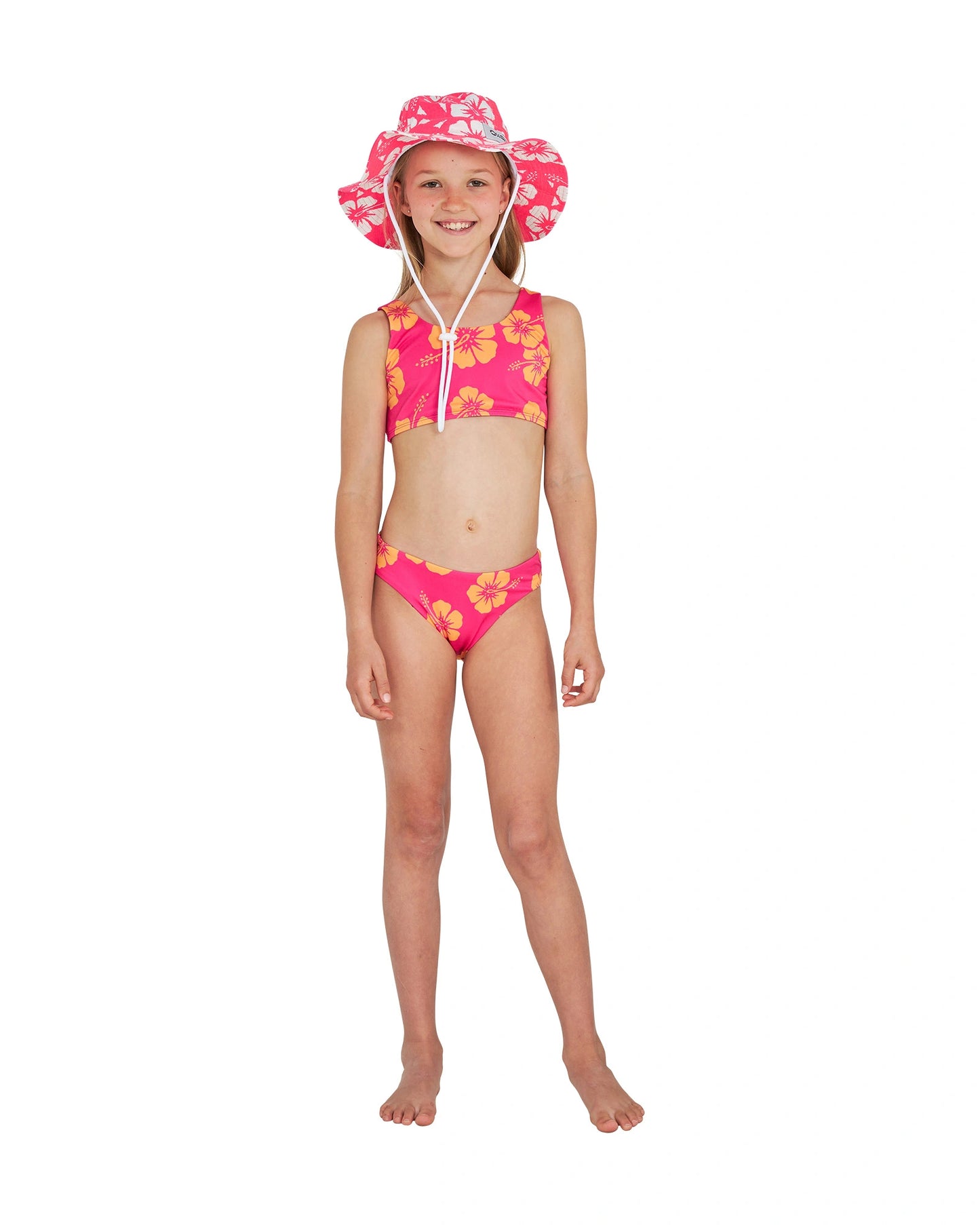 Full body front view of a girl in pink bucket hat paired with the Okanui crop bikini set in Hibiscus Pink Melon