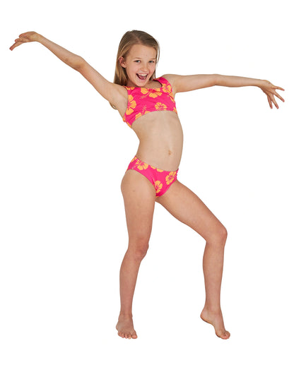 Joyfu pose of a girl wearing the Okanui crop bikini set in Hibiscus Pink Melon