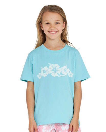 Closeup front view of a girl wearing the Okanui Logo Tee T-shirt in Washed Aqua