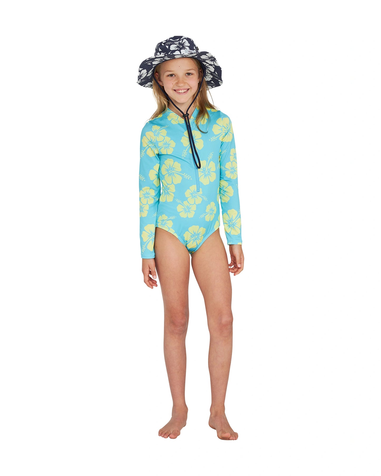 Full body front view of a girl in bucket hat wearing the Okanui long sleeve one piece swimsuit for girls in Hibiscus Aqua Yellow