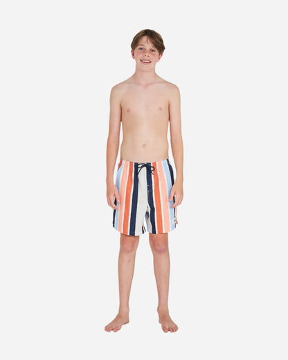 Full body front view of a topless boy wearing the Okanui stretch swim shorts in Birch Multi