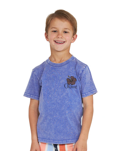 Closeup front view of a little boy wearing the Okanui Good Company Tee T-shirt in Washed Blue