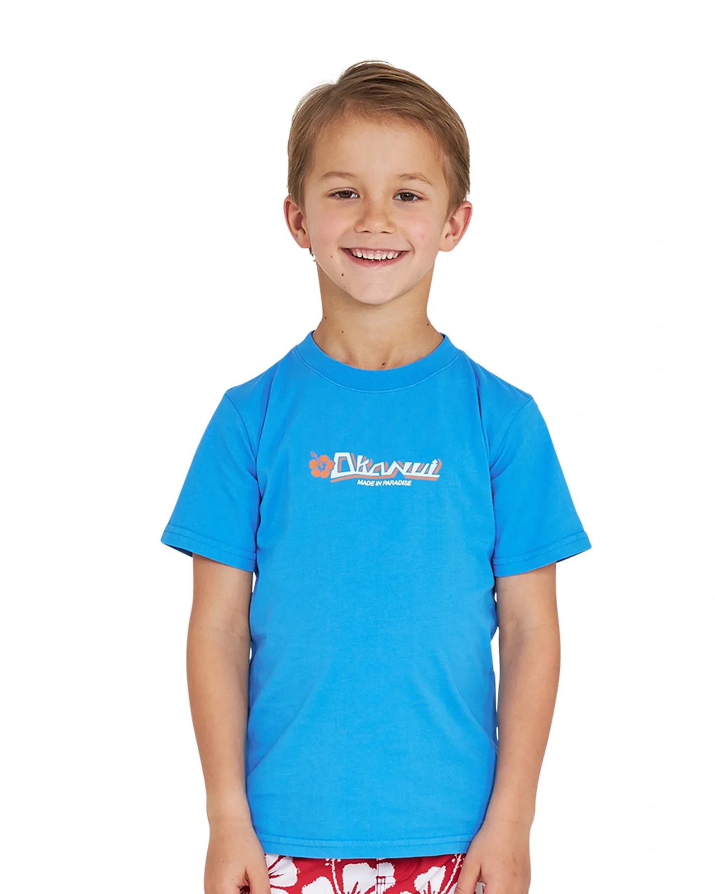 Closeup front view of a little boy wearing the Okanui Point Break Tee T-shirt in Washed Blue