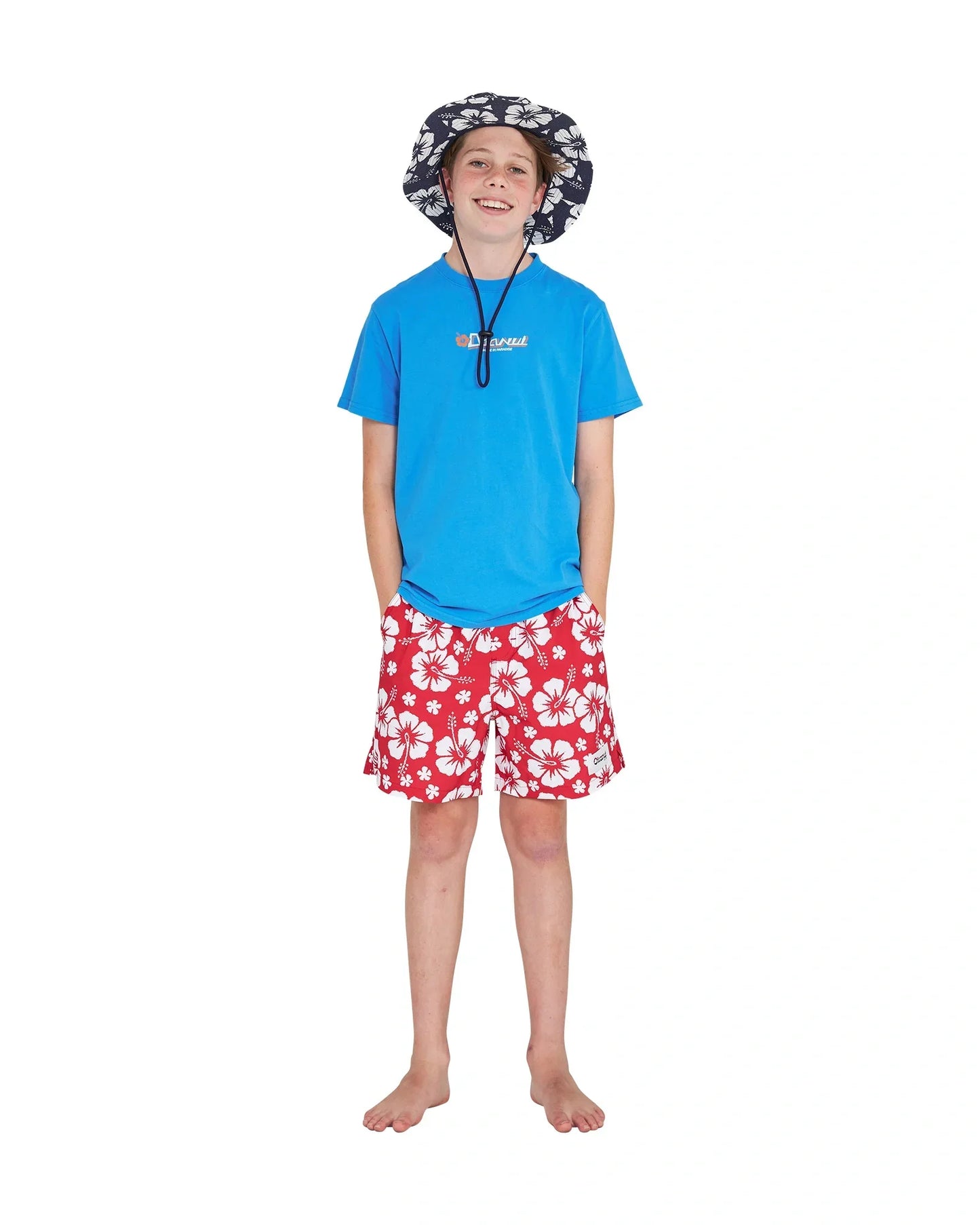 Hands in the pocket pose of boy wearing the Okanui bucket hat paired with the Okanui Point Break Tee T-shirt in Washed Blue