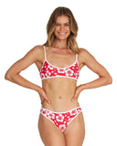 A woman wearing a two-piece bikini in hibiscus red showing the front details. 