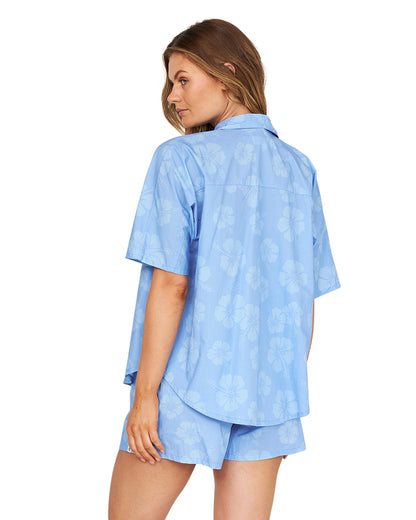 A serious casual pose of a model wearing a loose light blue shirt paired with a terno shorts.