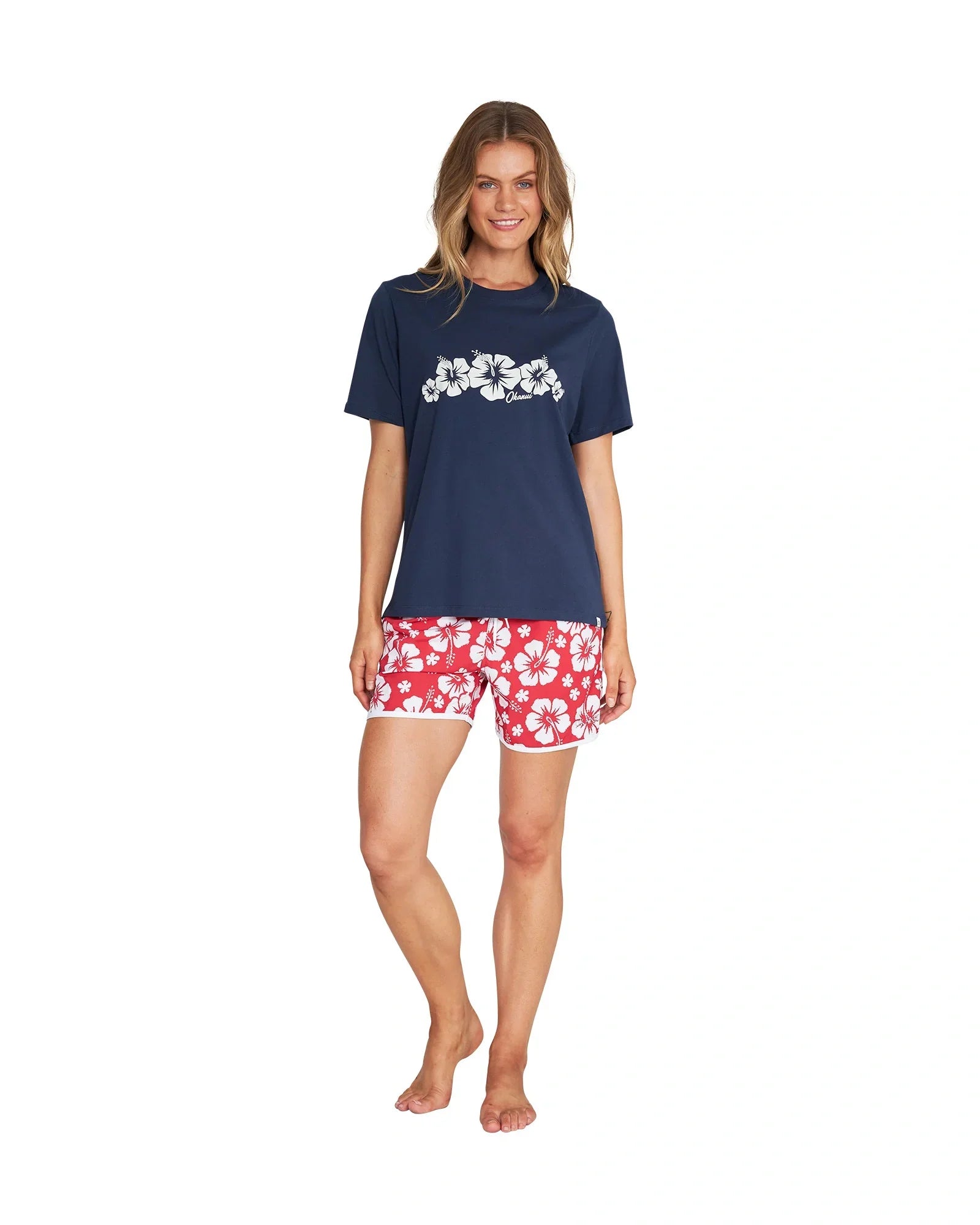 Full body front view of a female model wearing the Okanui Inline cotton T-shirt in navy color