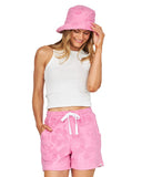 A female model wearing a pink bucket hat, white tank top and the Okanui Weekender Terry Short in Hibiscus Pink.