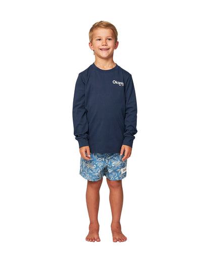 Full body front view of a little boy wearing the Okanui classic badge long sleeve T-shirt in Navy