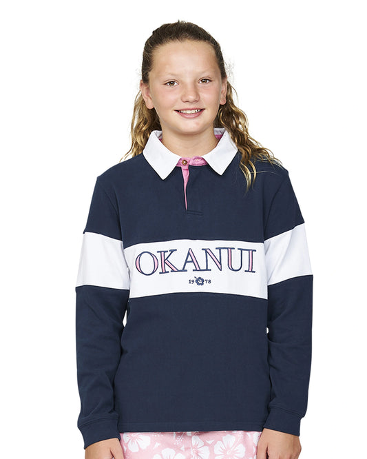 Closeup front view of a girl wearing the Okanui Girls Heritage long sleeve Rugby tops and jumpers in Navy/White