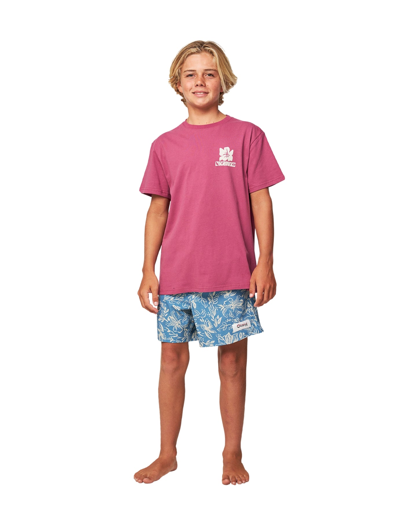 Full body front view of a boy wearing the Okanui Kids swim shorts in Steel