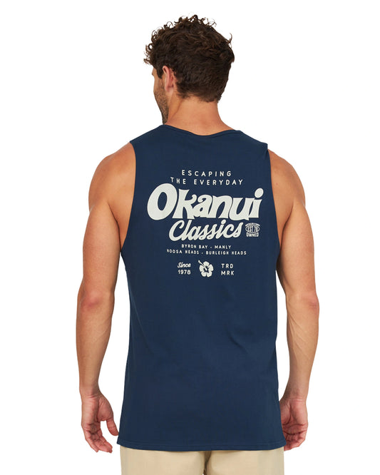 A male model with his back on the camera wearing the Okanui Big Screen Tank in Navy.