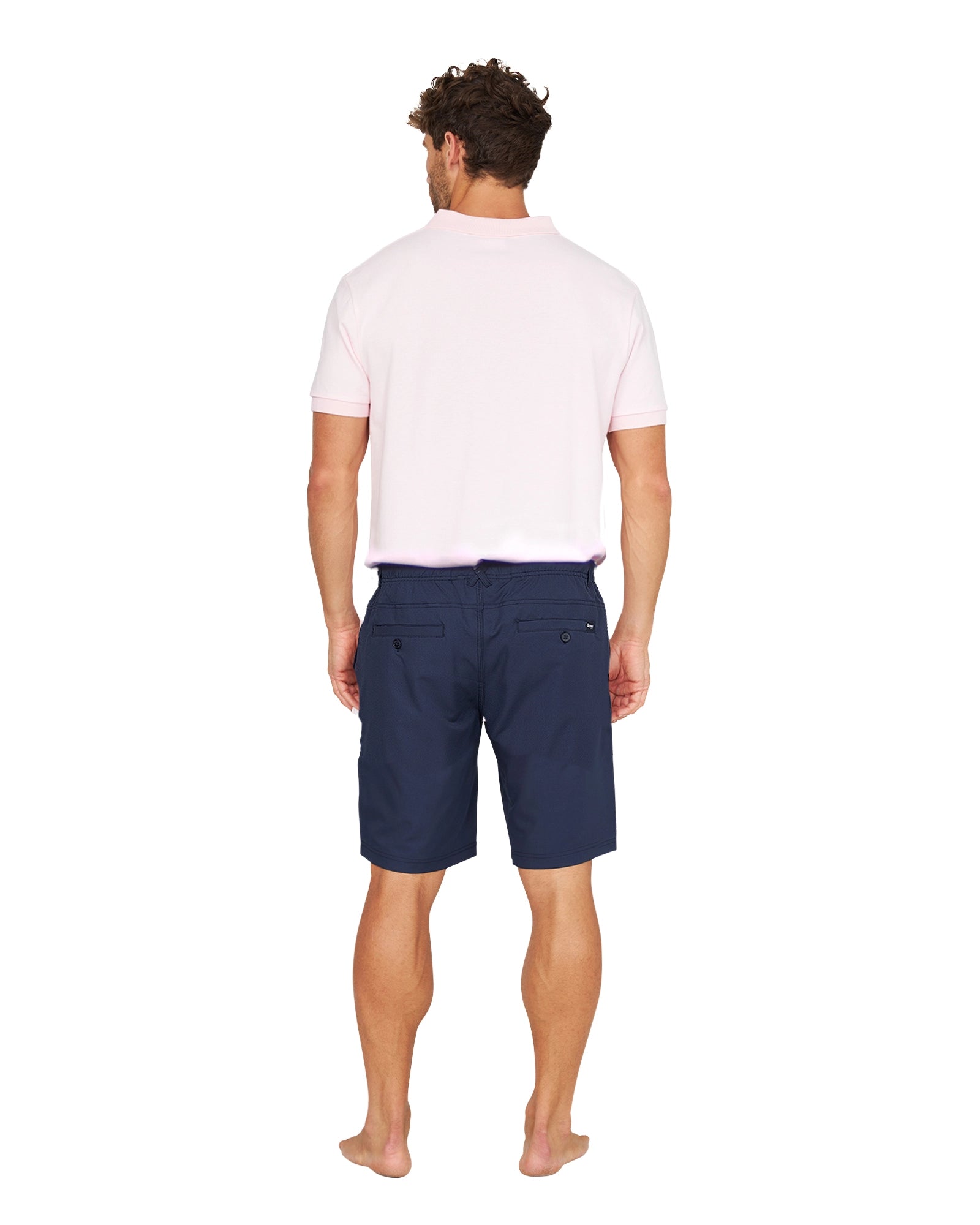 Full body back view of a male model wearing the Okanui Active Byrd Golf Shorts in navy.