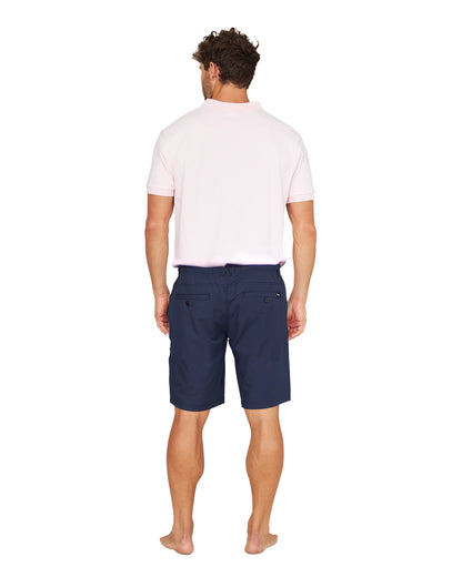 Full body back view of a male model wearing the Okanui Active Byrd Golf Shorts in navy.