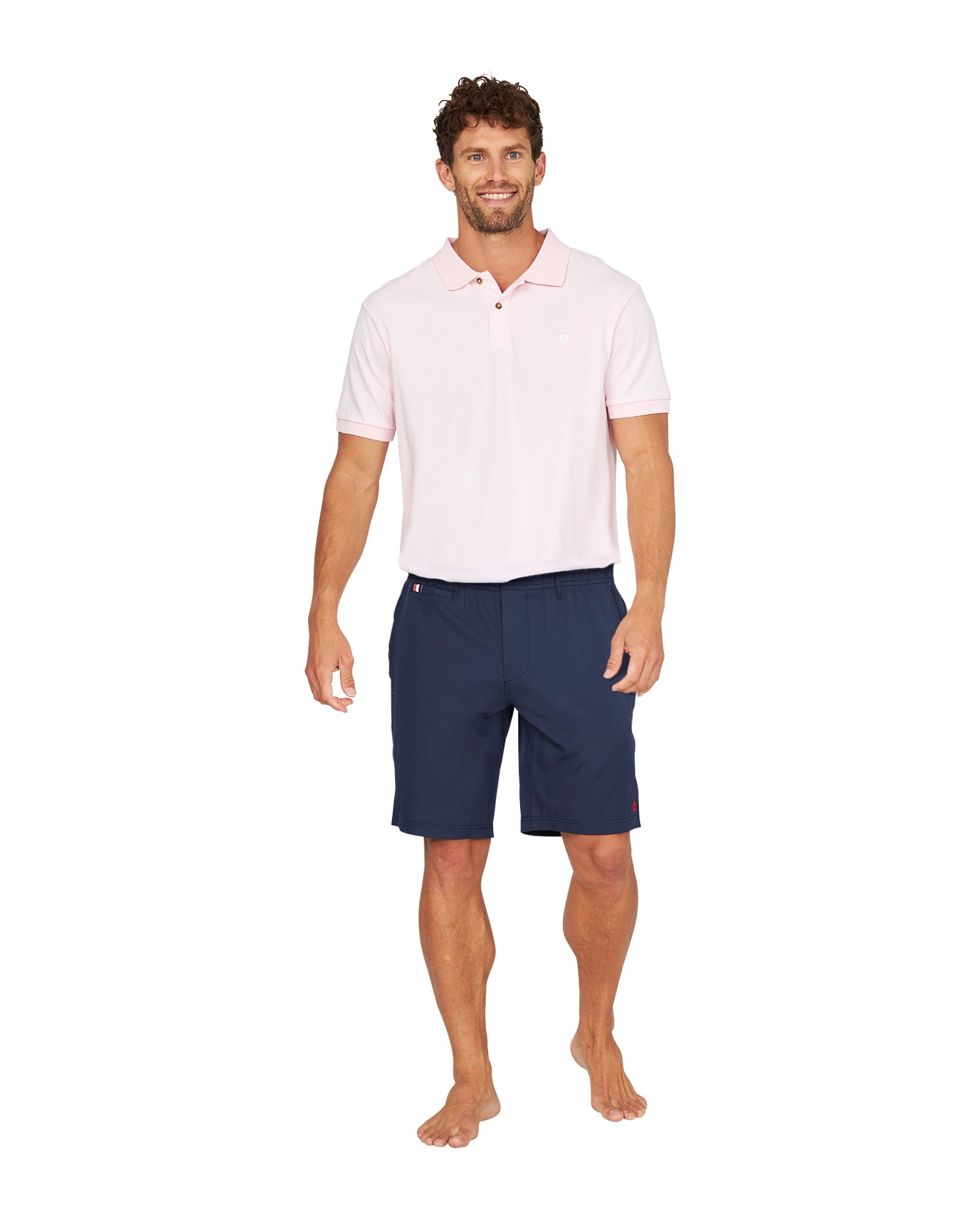 Full body view of a male model wearing the Okanui Active Byrd Golf Shorts in navy.