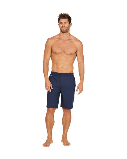 A shirtless male model wearing the Okanui Active Byrd Golf Shorts in navy.