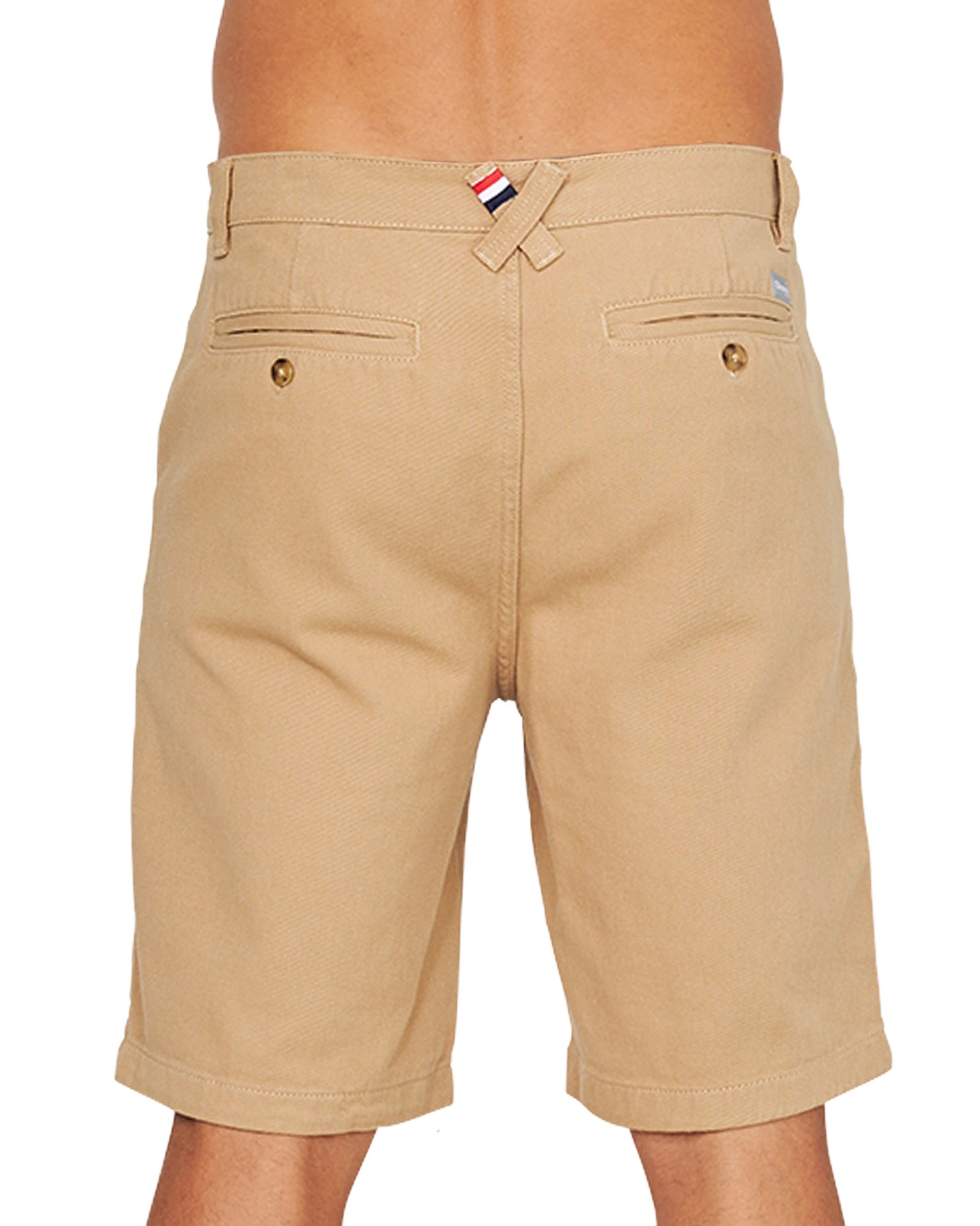 A close up back view of the Okanui Dockside Walk Short in sand with twin hip pockets and double back welt pockets with button closure.