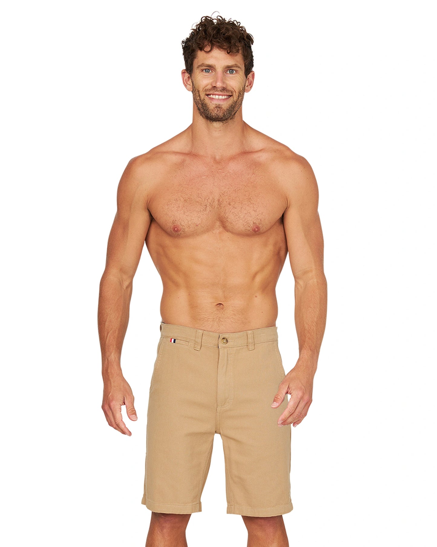 A full body front view of a shirtless male model wearing the Okanui Dockside Walk Short in Sand.