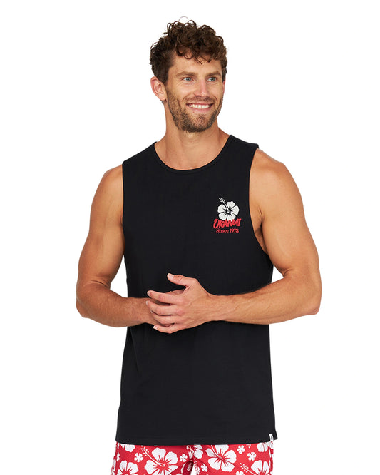 A male model casually posing wearing the Okanui Eclipse Tank in Washed Black color.