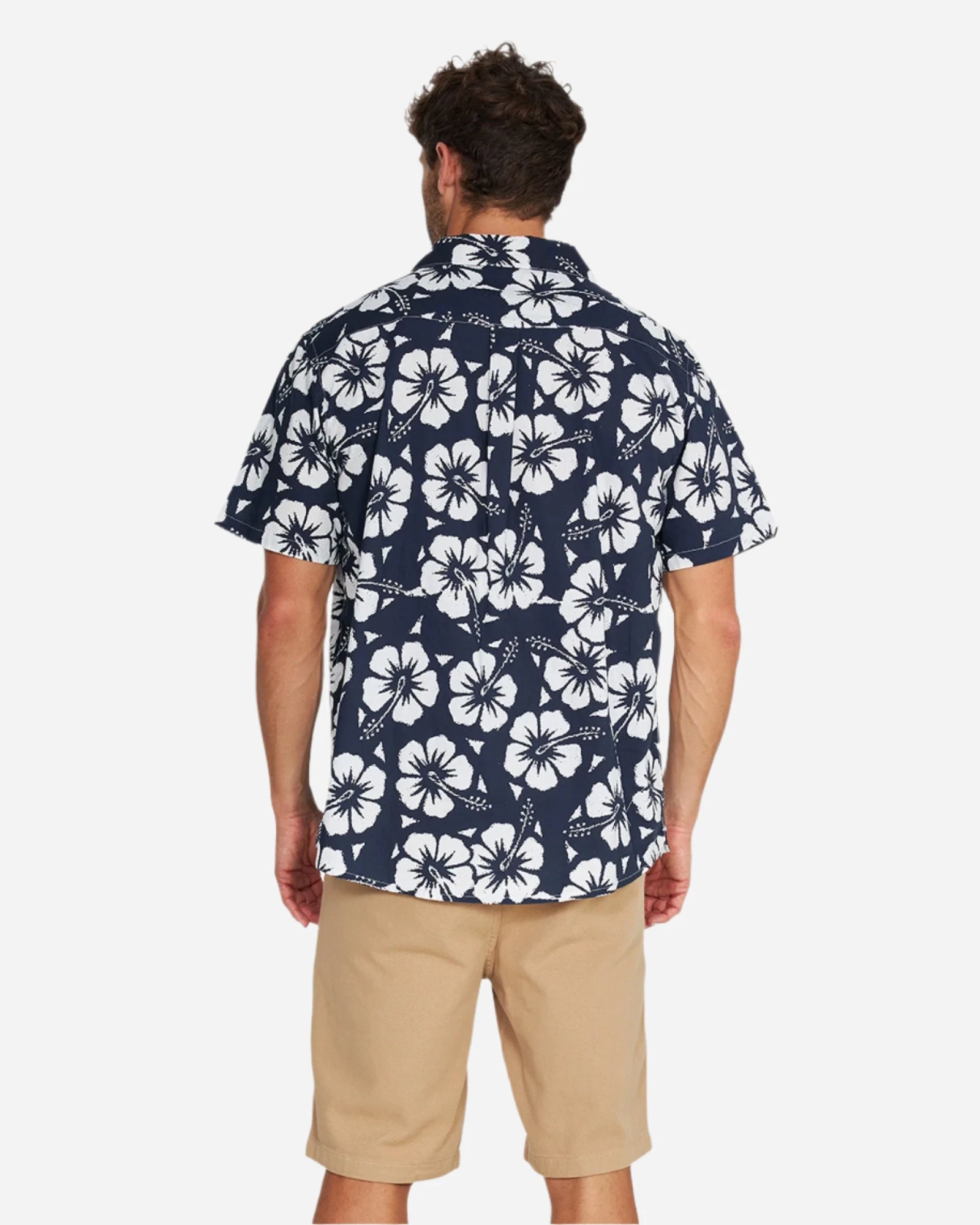 A relaxed back pose of a male model wearing the Okanui Classic Hawaiian Shirt in Hibiscus navy.