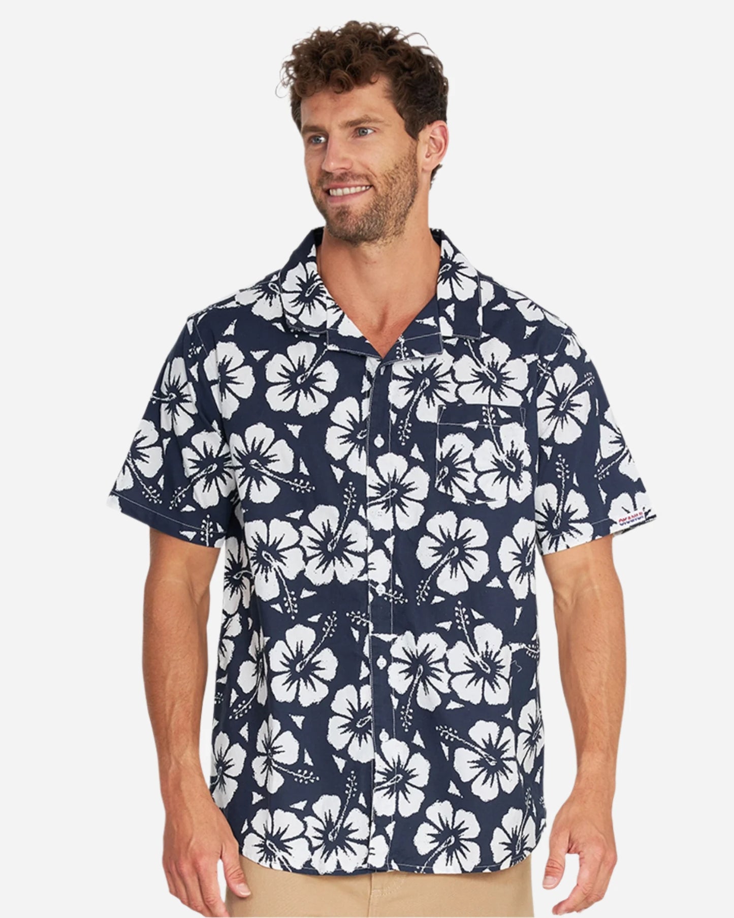 The Okanui Classic Hawaiian Shirt in Hibiscus navy color for men worn by a model in a white background studio.