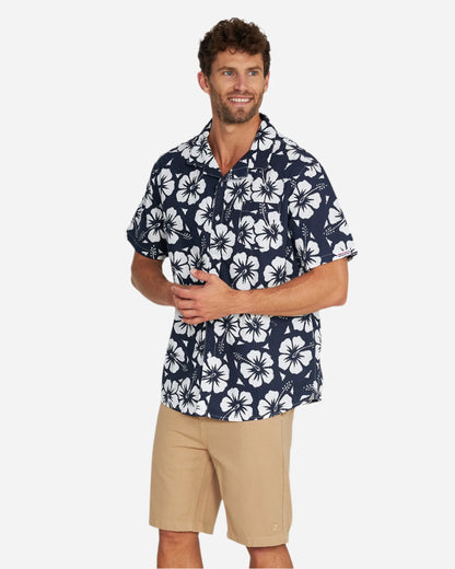 A male model in a front view pose wearing the Okanui Classic Hawaiian Shirt in Hibiscus navy.