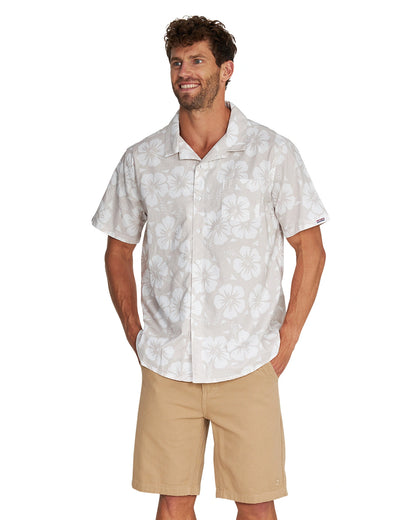 Front view of a male model wearing the Okanui Classic Button up short sleeve shirt in Hibiscus Stone with his hands in the pocket pose