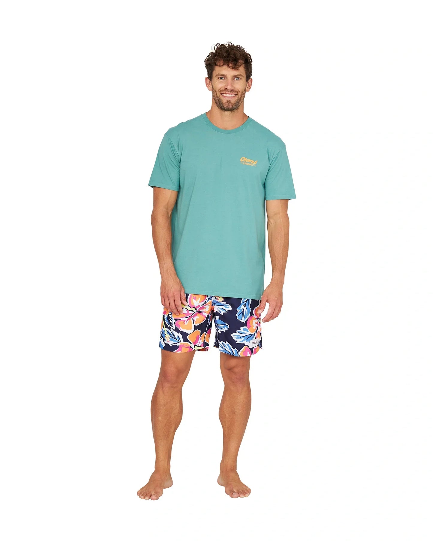 A full body view of a male model wearing the Okanui Rhapsody Swim Short in navy multi.