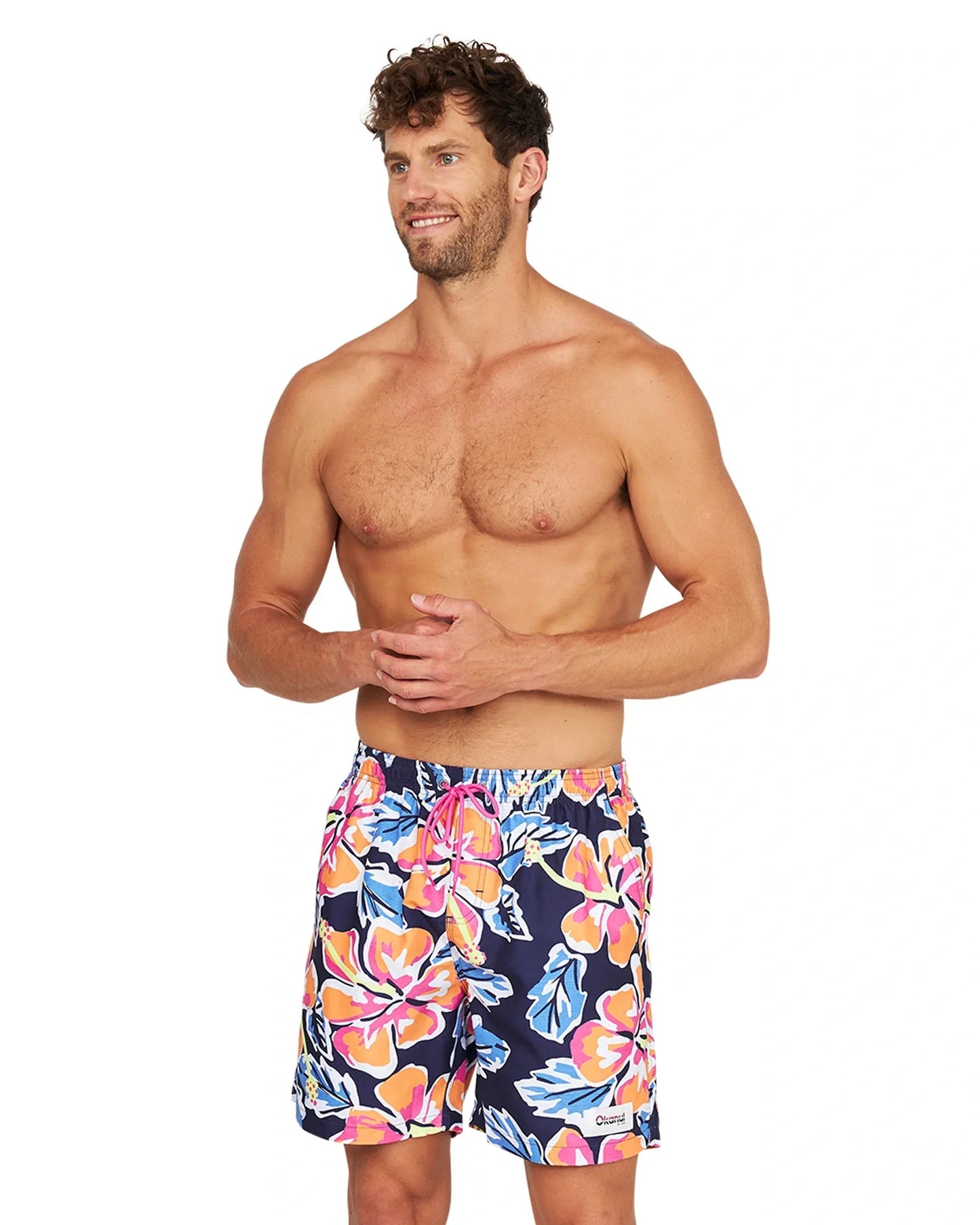 A fit male model wearing the Okanui Rhapsody Swim Short in navy multicolor in a slightly side view angle.