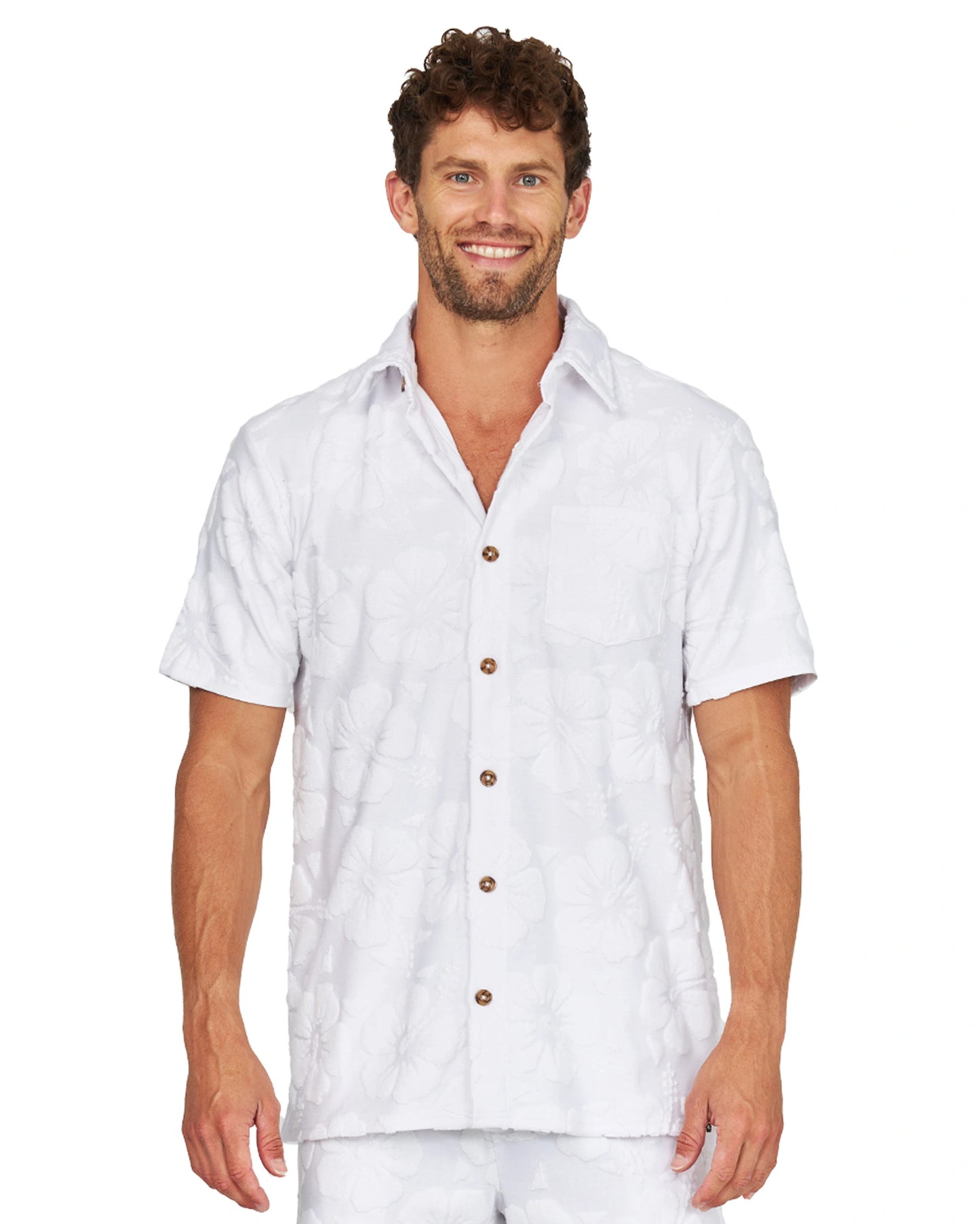 A male model wearing the Okanui Starboard Short Sleeve Shirt in Hibiscus white.