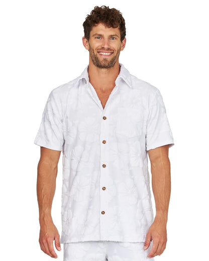 A male model wearing the Okanui Starboard Short Sleeve Shirt in Hibiscus white.