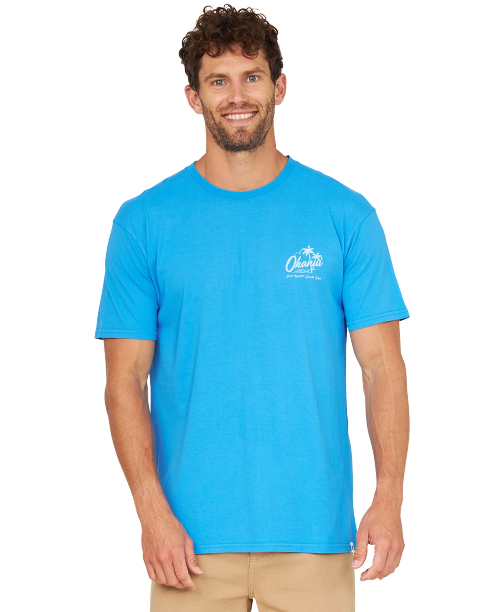 Closer front view of a male model wearing the Okanui Mens Postcards Tee in washed blue color.