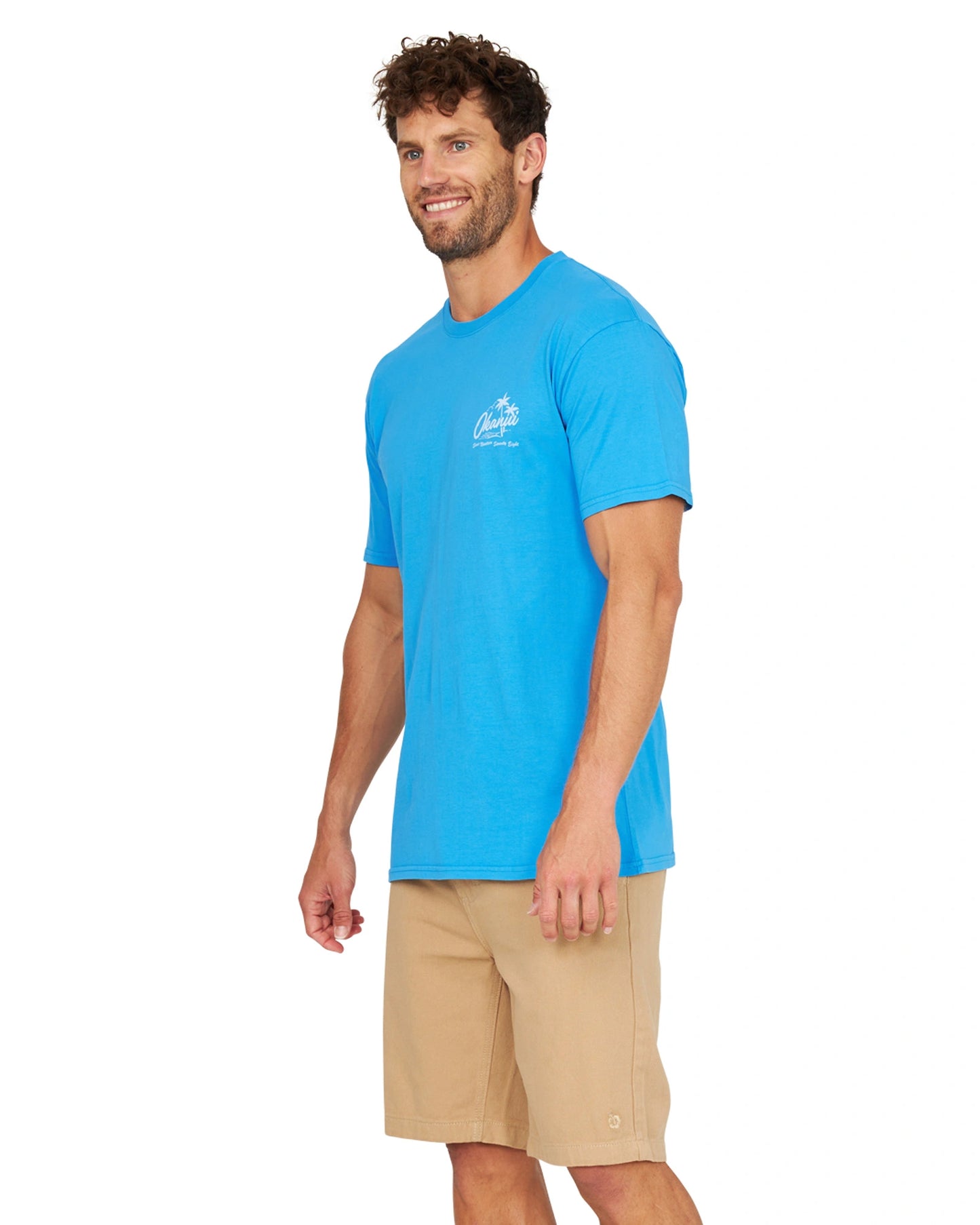 Side view of a male model wearing the Okanui Mens Postcards Tee in washed blue.