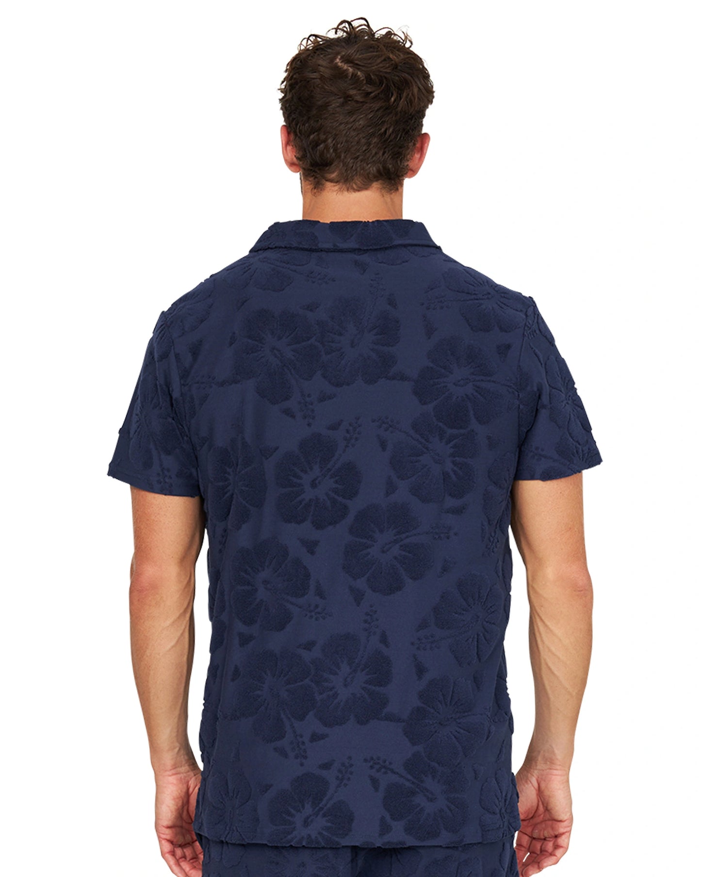 Closer back view of male model wearing the Okanui Weekend Terry Jacquard Polo in Hibiscus Navy.