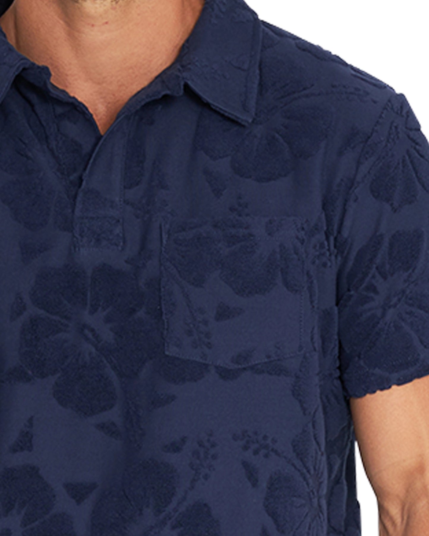 Close up photo of the collar wearing the Okanui Weekend Terry Jacquard Polo in Hibiscus Navy.