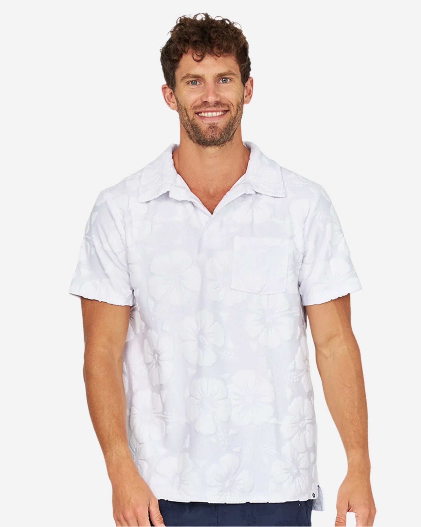 A smiling male model wearing the Okanui Weekend Terry Jacquard Polo in Hibiscus White.