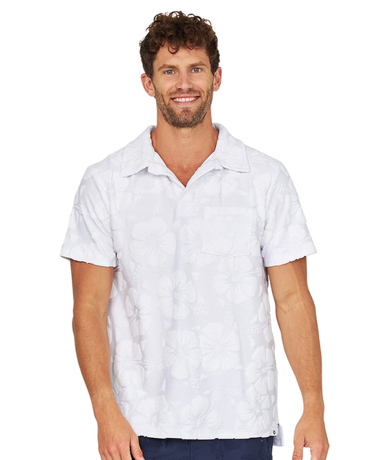 A smiling male model wearing the Okanui Weekend Terry Jacquard Polo in Hibiscus White.