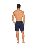 The back view of a fit male model wearing the Okanui Weekend Terry Jacquard Walk Shorts in navy color with his hand in the left side pocket.
