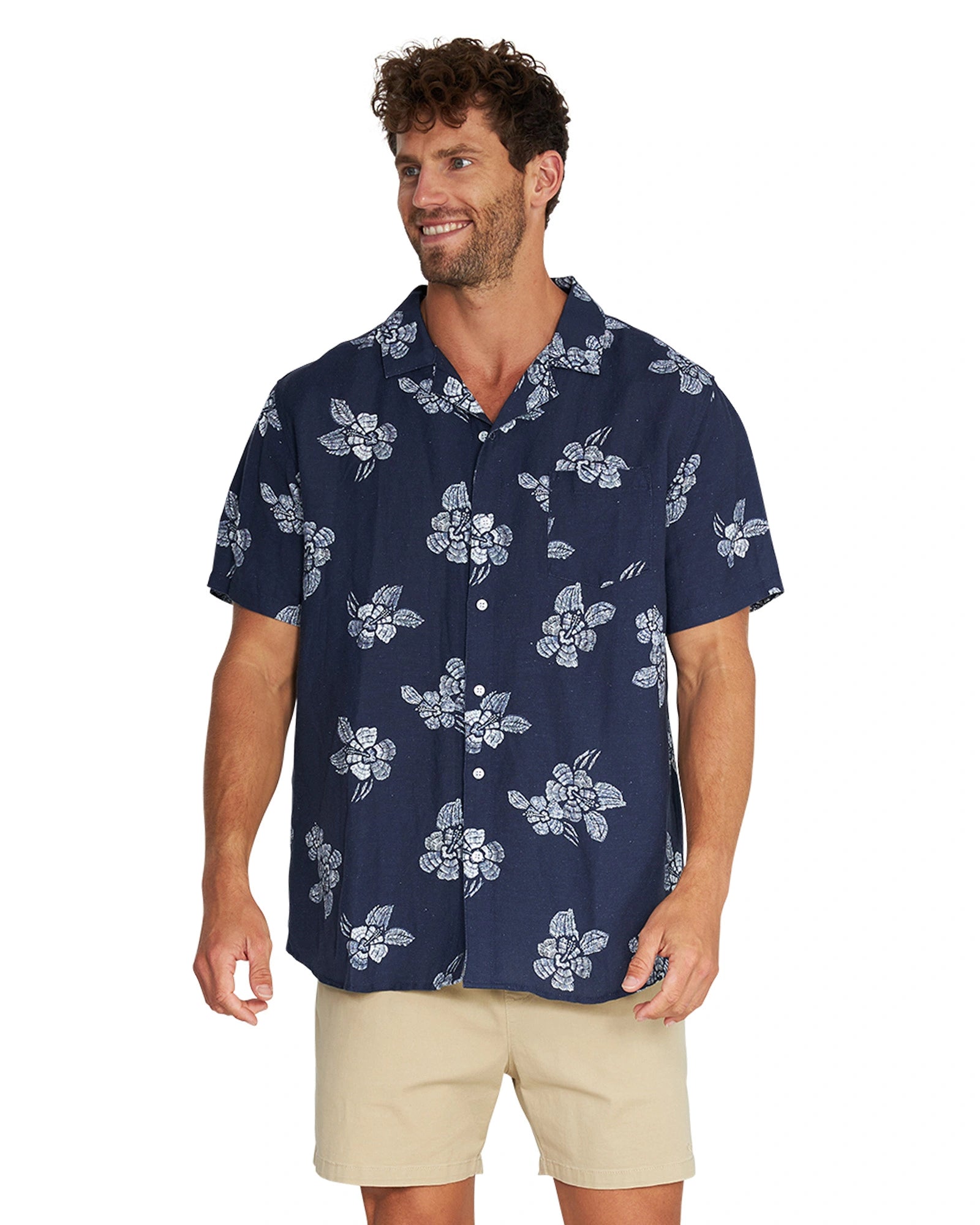 A smiling male model wearing the Okanui Whitewater Aloha Short Sleeve Shirt in navy color.