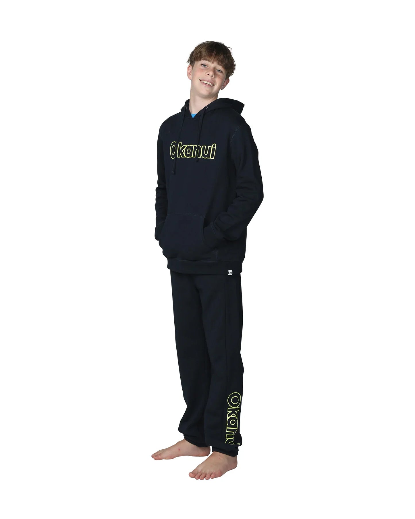 Full body front view of a boy wearing the Okanui Winter Keyline trackies for Kids in Navy color paired with a Navy color Okanui Jacket