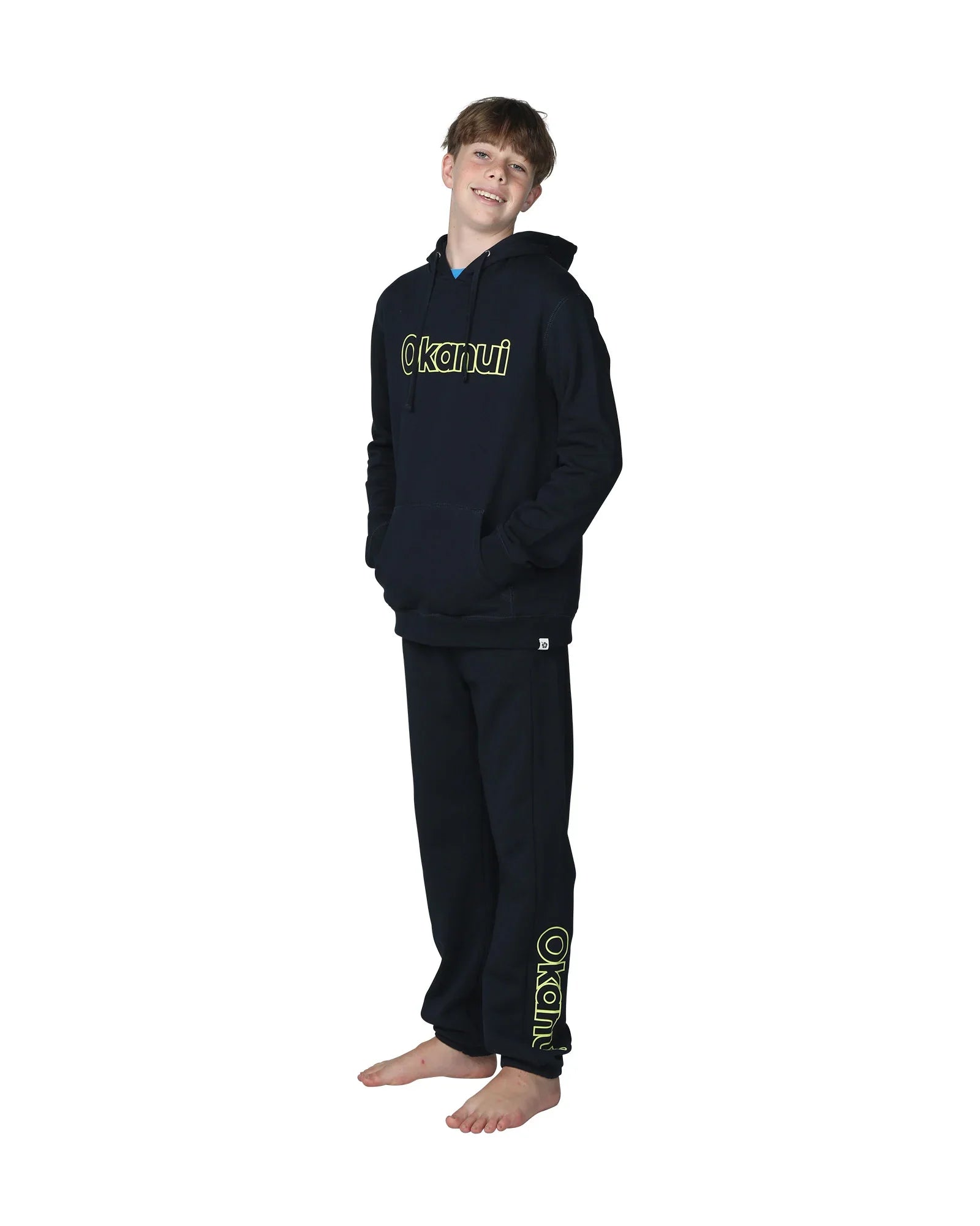 Full body front view of a boy wearing the Okanui Winter Keyline trackies for Kids in Navy color paired with a Navy color Okanui Jacket