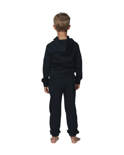 Full body back view of a little boy wearing the Okanui Winter Keyline trackies for Kids in Navy color paired with a Navy color Okanui jacket