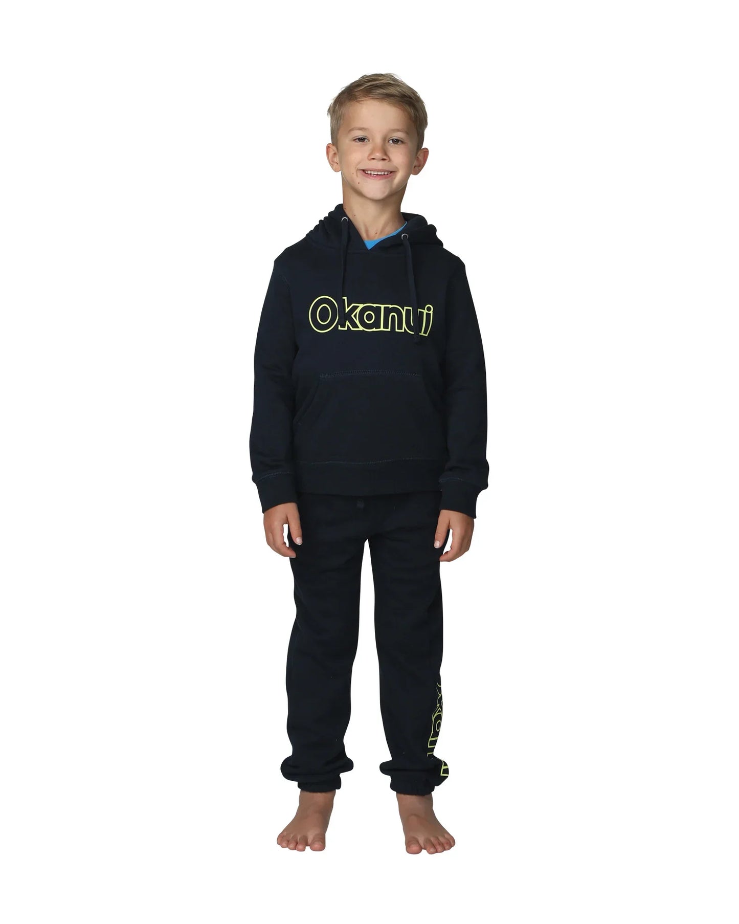Full body front view of a little boy wearing the Okanui Winter Keyline trackies for Kids in Navy color paired with a Navy color Okanui jacket