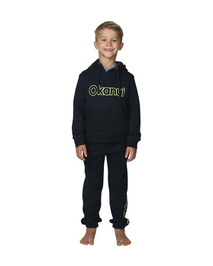 Full body front view of a little boy wearing the Okanui Winter Keyline trackies for Kids in Navy color paired with a Navy color Okanui jacket