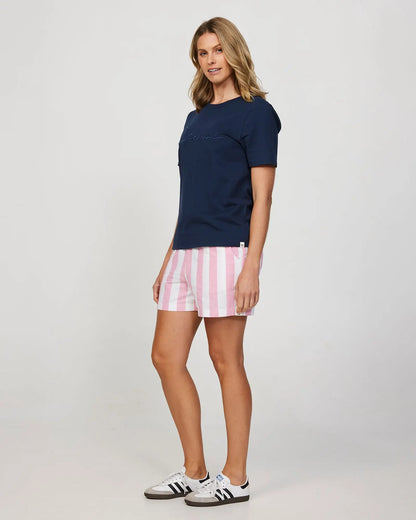 Full body front-left view of a female model wearing the Okanui Womens Holiday Beach Short in Classic Stripe Pink