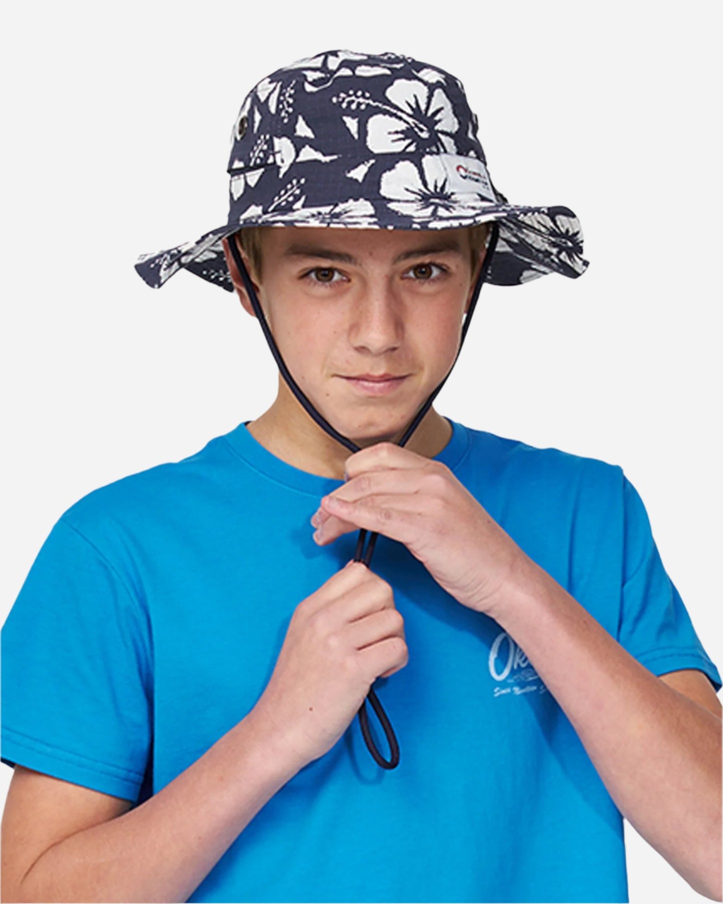 Front view of a boy model wearing the Okanui Classic Boonie Hat in Hibiscus Navy Print