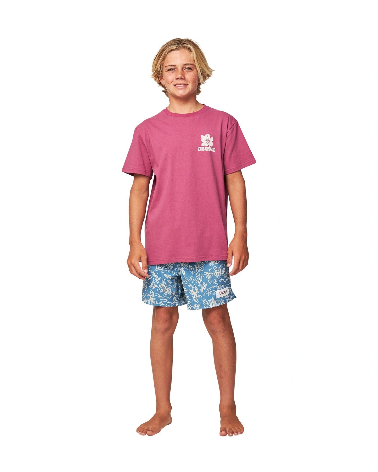 Full body front view of a boy wearing the Okanui Jungle Tee T-shirt in Garnet